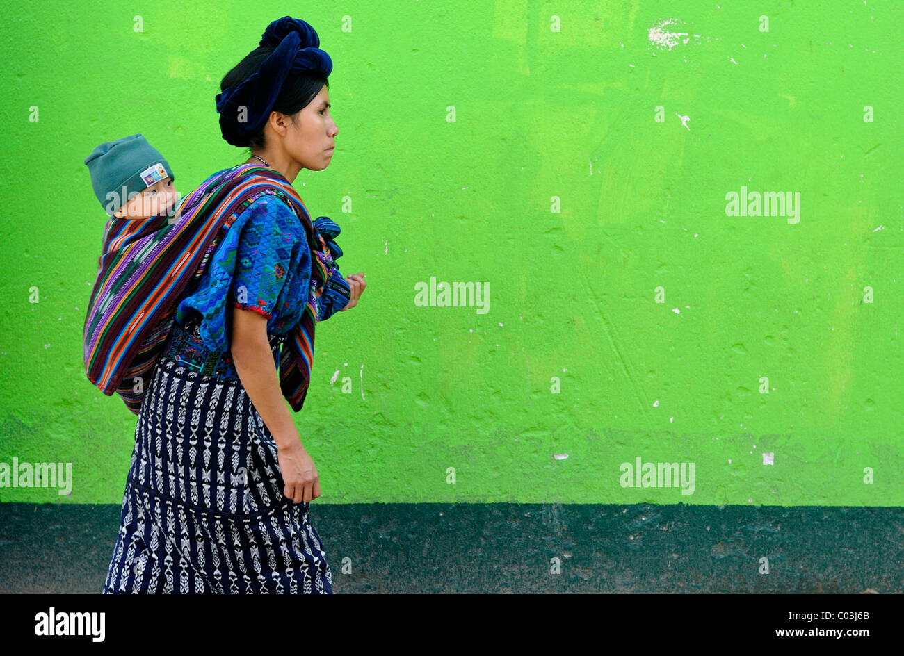 Mayan woman carrying a child, Antigua, Guatemala, Central America Stock Photo