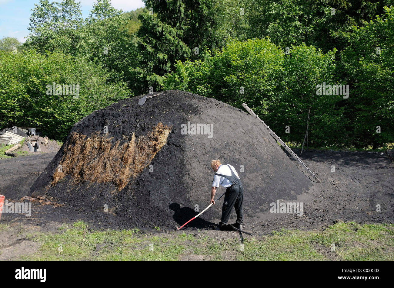 A new charcoal kiln being covered with turf and sealed with coal earth
