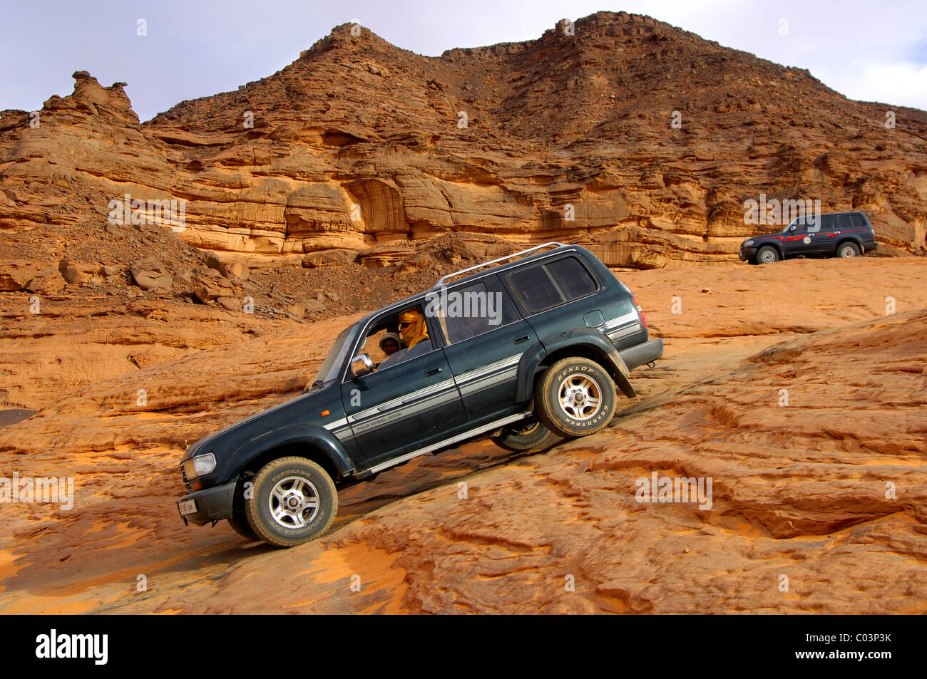 Off-road vehicle passing in a steep rock passage, Acacus Mountains, Sahara desert, Libya Stock Photo