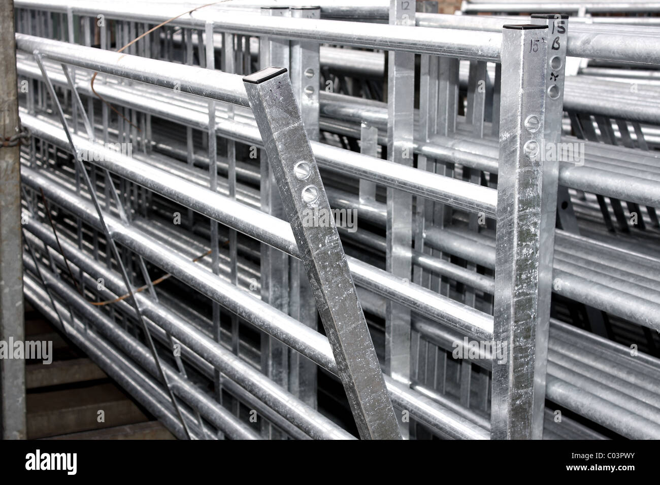 Cattle bar gates stacked up together in an industrial yard Stock Photo
