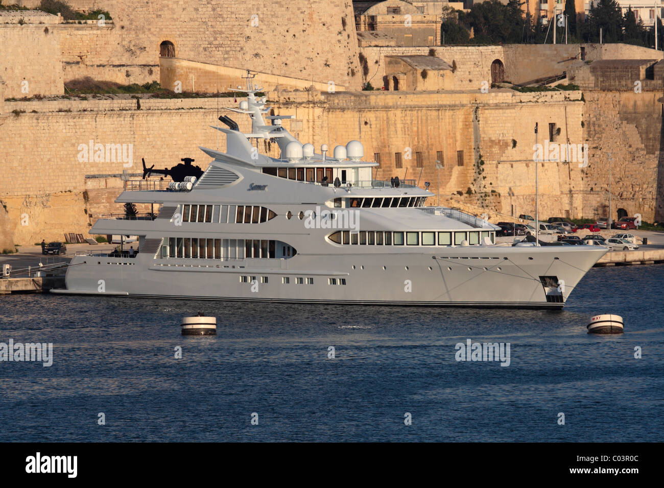 The superyacht Samar moored beneath Fort St Angelo, Malta, with a helicopter on its upper stern deck Stock Photo