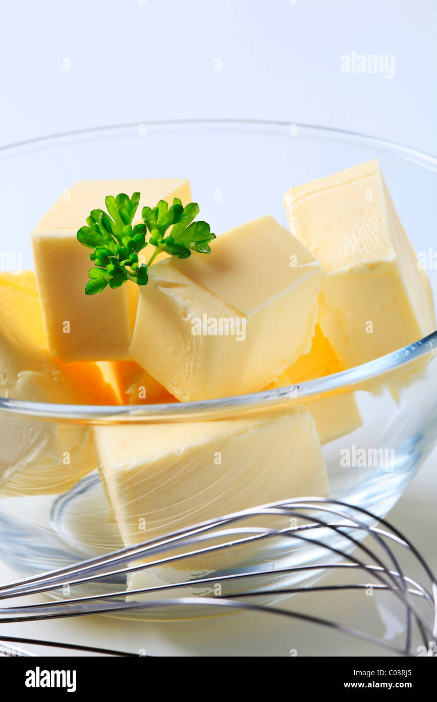 Blocks of fresh butter in a bowl and metal whisk Stock Photo Alamy