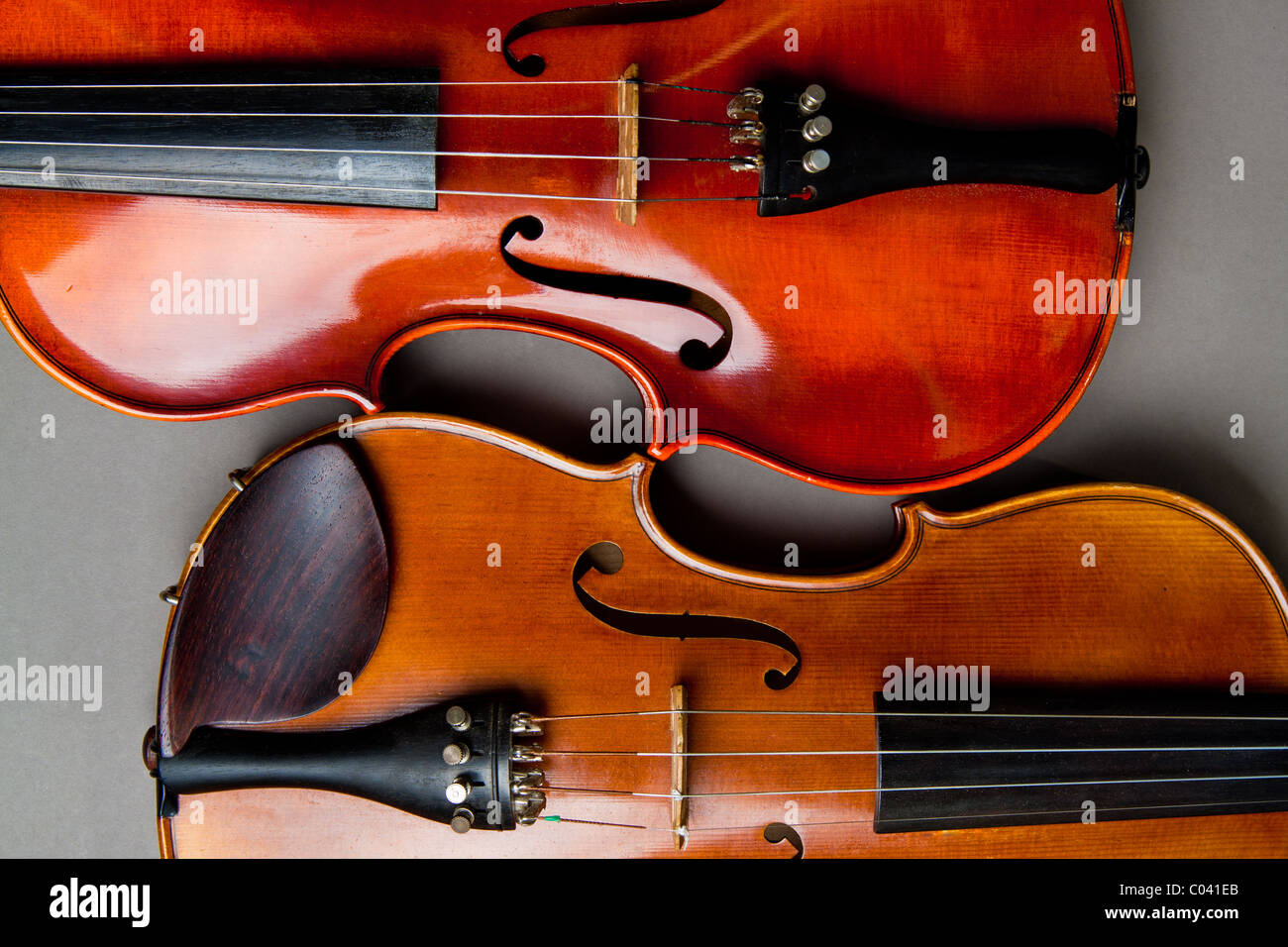 The 'C' bouts and f holes of two classical violins or fiddles on a grey background. Stock Photo