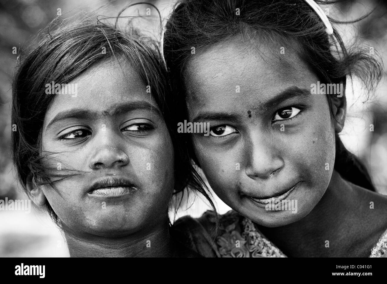 Thoughtful young poor lower caste Indian street girls. Sisters. Black and white. Andhra Pradesh, India Stock Photo