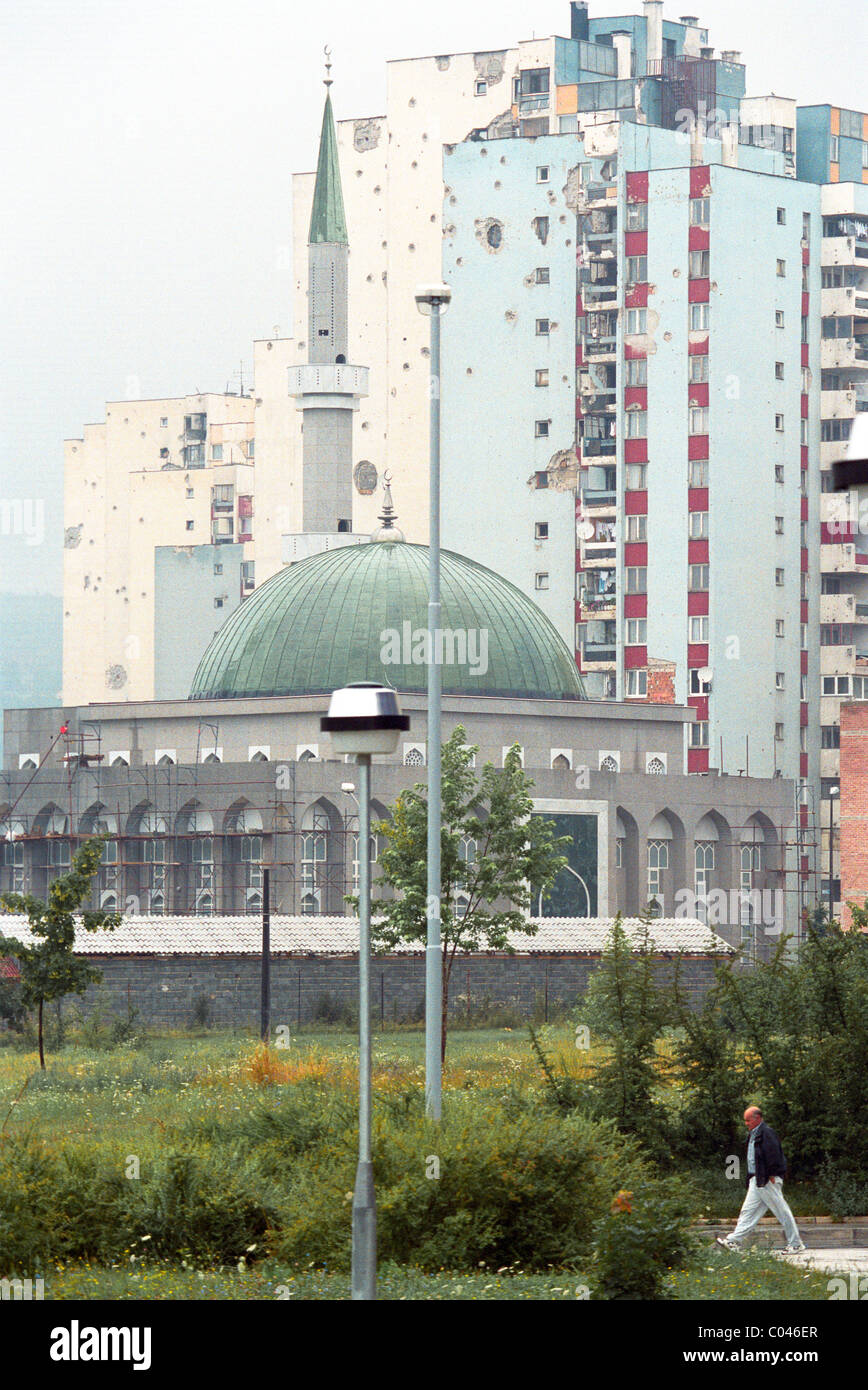 New mosque in Sarejevo funded by Saudi Arabian interests juxtaposed against war damaged apartment blocks Stock Photo