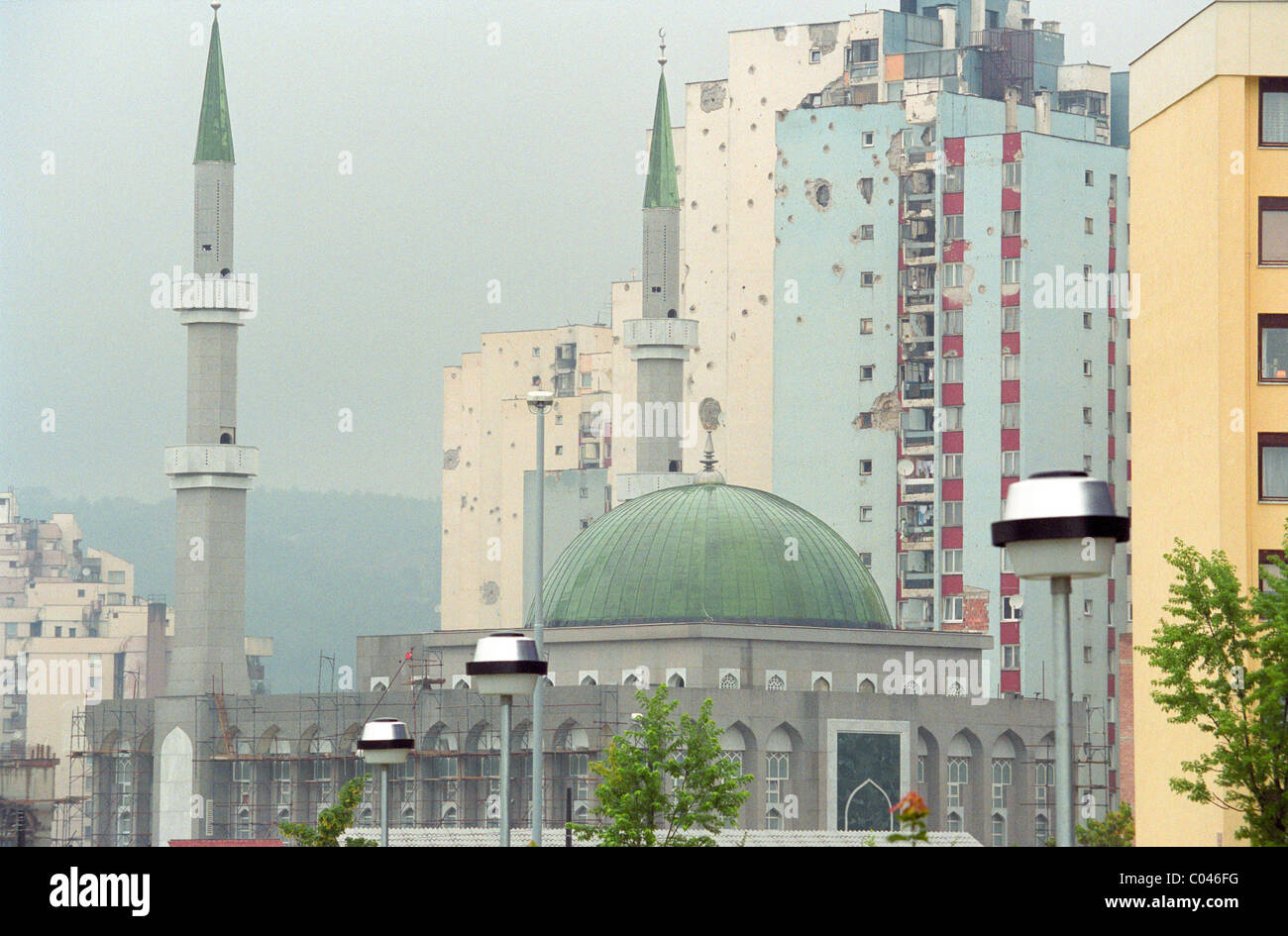 A newly built mosque sponsored by Saudi Arabia in front of war damaged apartment blocks in Sarejevo Stock Photo