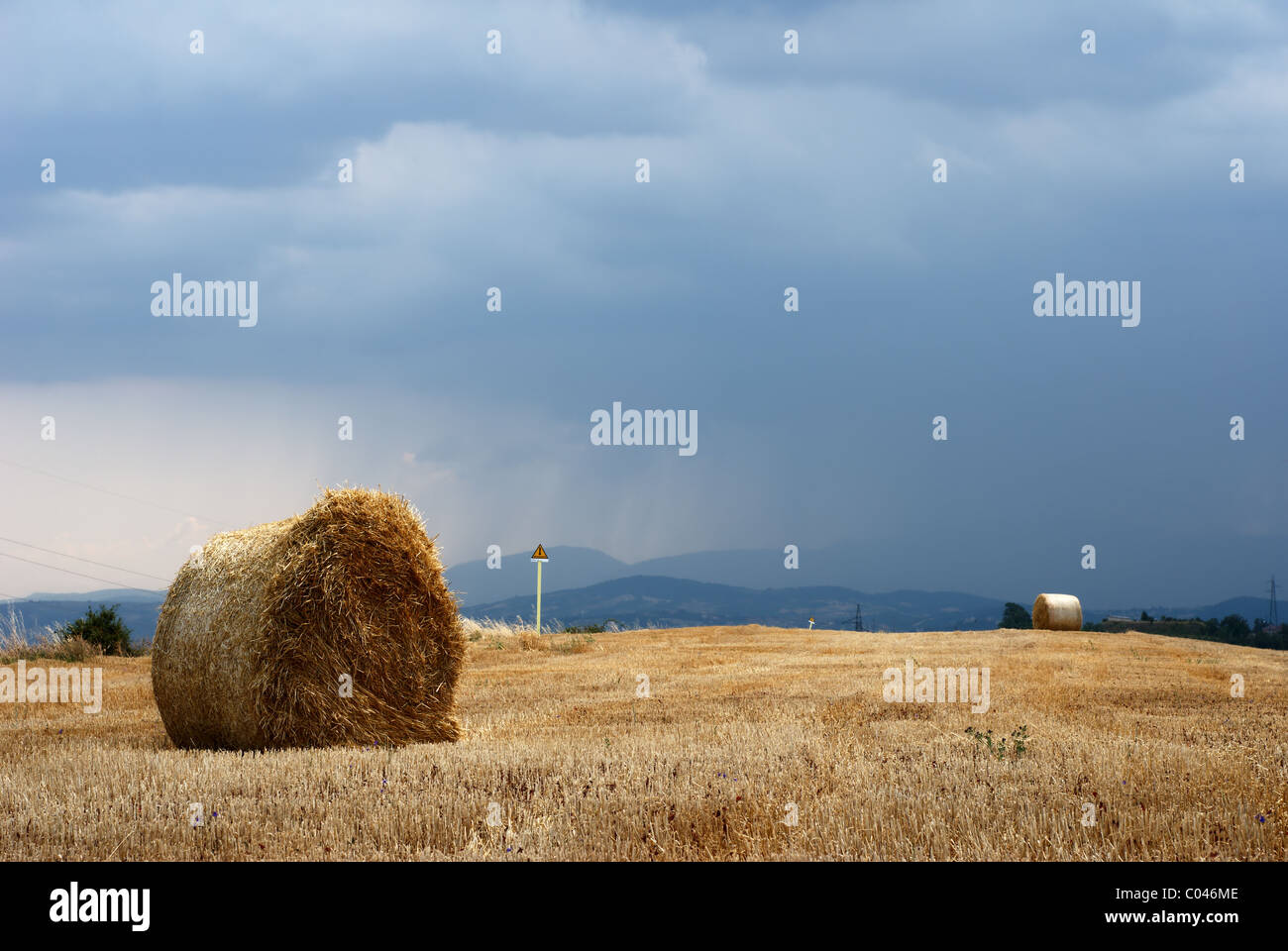 Straw bales in a field under moody sky Stock Photo - Alamy
