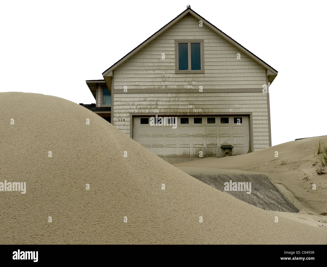 Sand dunes pile up around vacation homes after a storm on the Oregon coast . Stock Photo