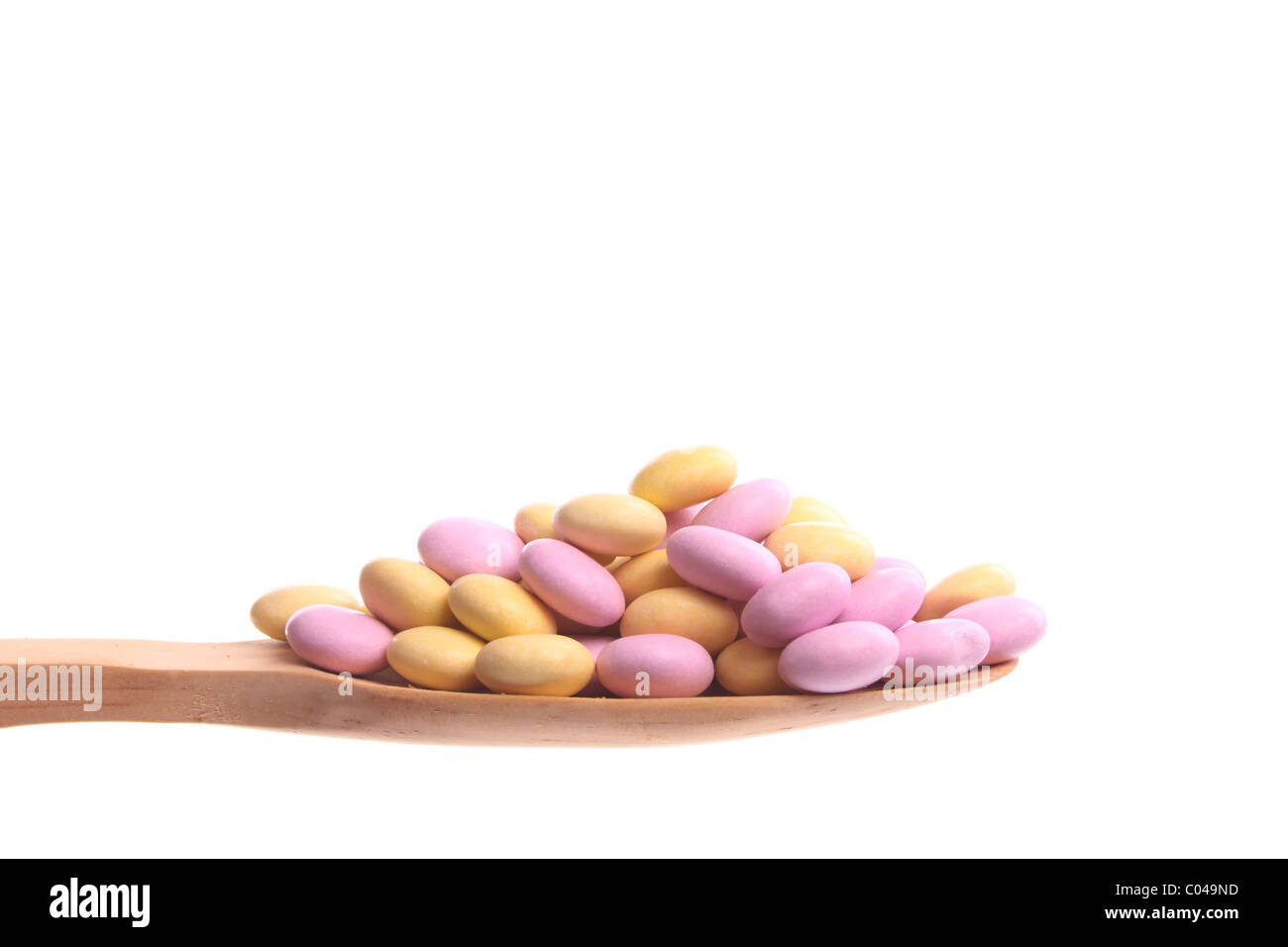 Sweeties simply offered on a wooden spoon isolated on a white background Stock Photo
