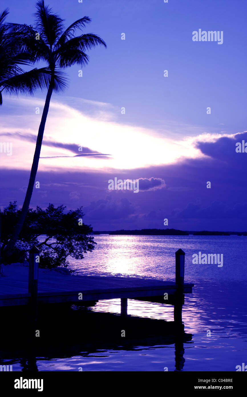 The sun sets behind a cloud bank in this tropical sunset on a Florida Keys island. Stock Photo