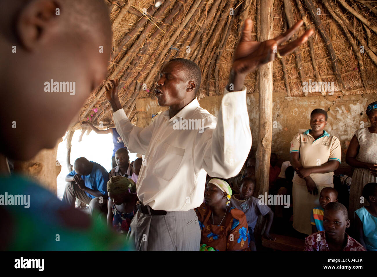 A pastor prays in a church in rural northern Uganda, East Africa. Stock Photo