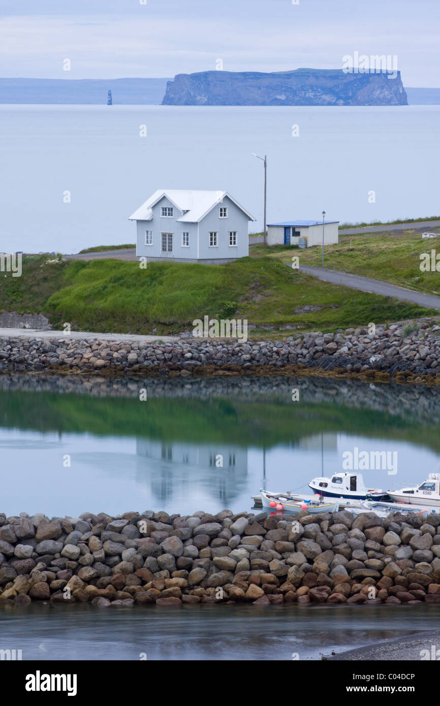 House by the harbour in Hofsos, Iceland, the island Drangey in the distance. Stock Photo
