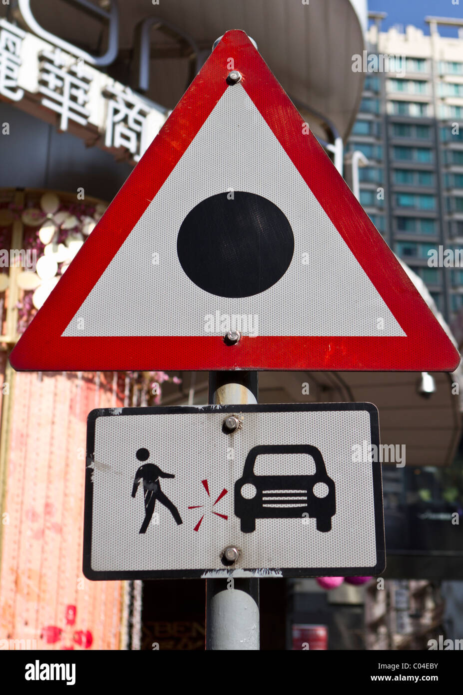 Curious road sign in Hong Kong at a pedestrian crossing warning pedestrians of the risk of an accident Stock Photo