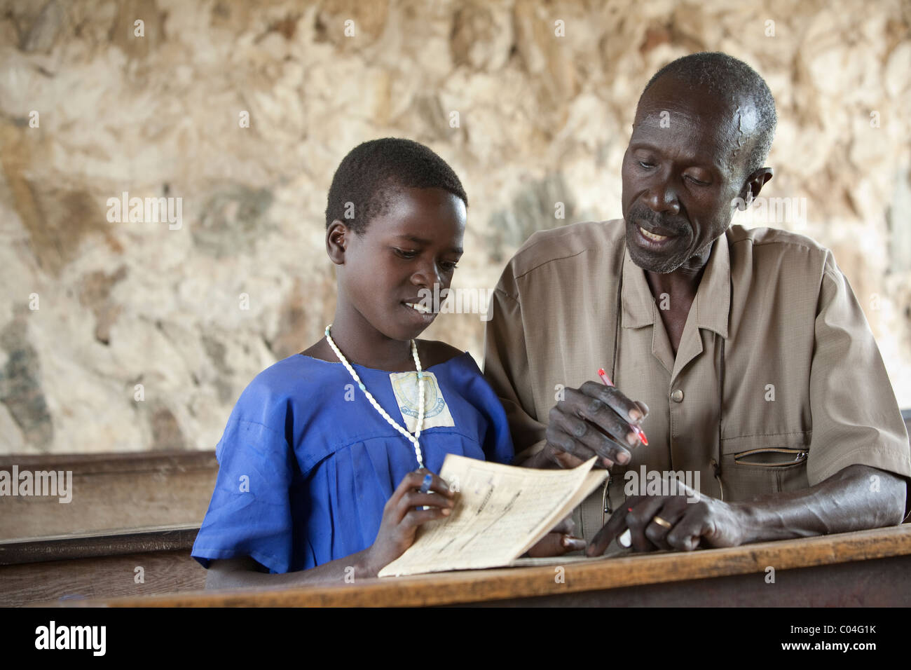 Teacher looks at student's school work in Amuria, Uganda, Teso. Stock Photo