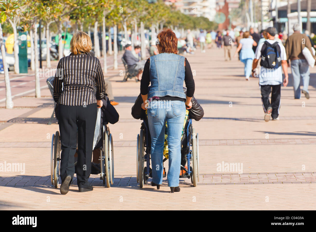 Two women pushing wheelchairs on promenade at Los Boliches, Fuengirola
