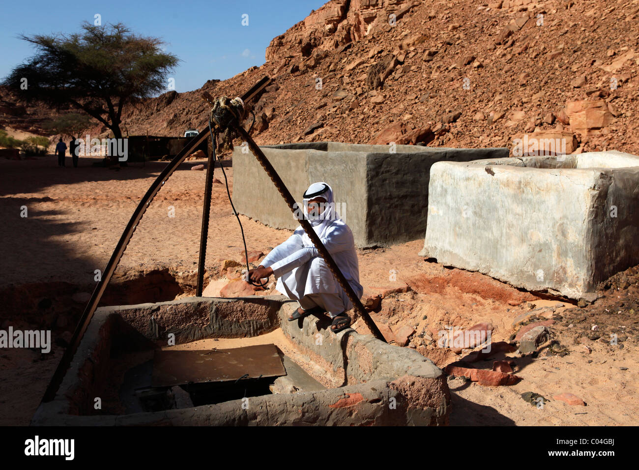 An Arab man squats by a well in the Sinai Desert, Egypt Stock Photo Alamy