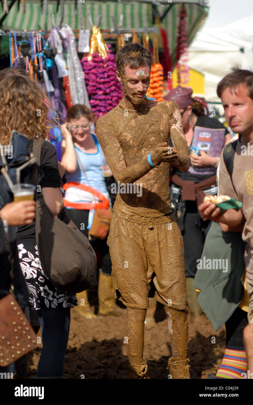 Young man covered in mud and dancing at WOMAD Festival, Malmesbury
