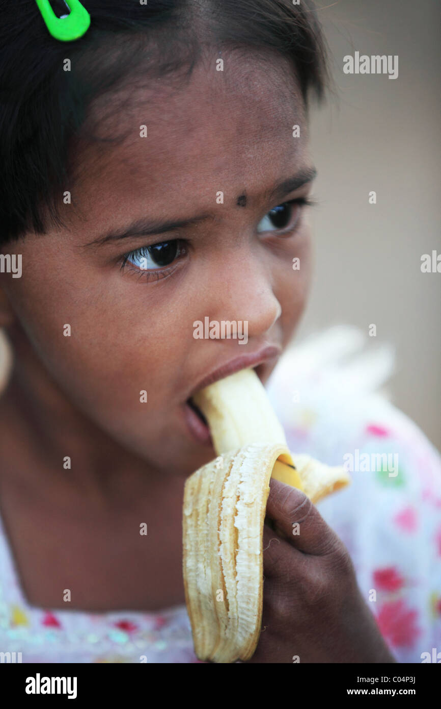 girl eating a banana Andhra Pradesh South India Stock Photo - Alamy
