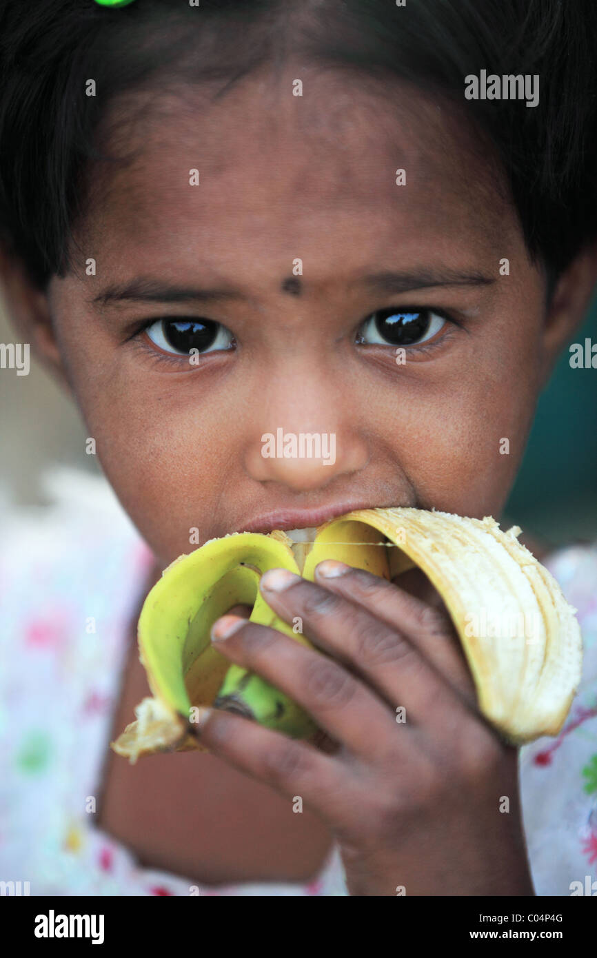 girl eating a banana Andhra Pradesh South India Stock Photo - Alamy