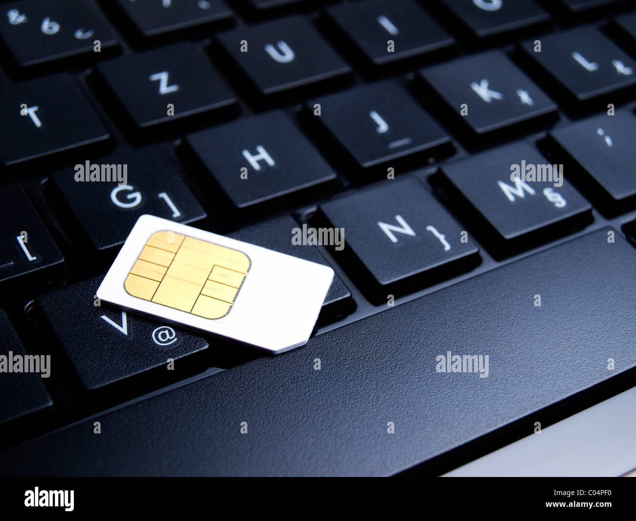 SIM card on laptop keyboard represents mobile internet Stock Photo - Alamy