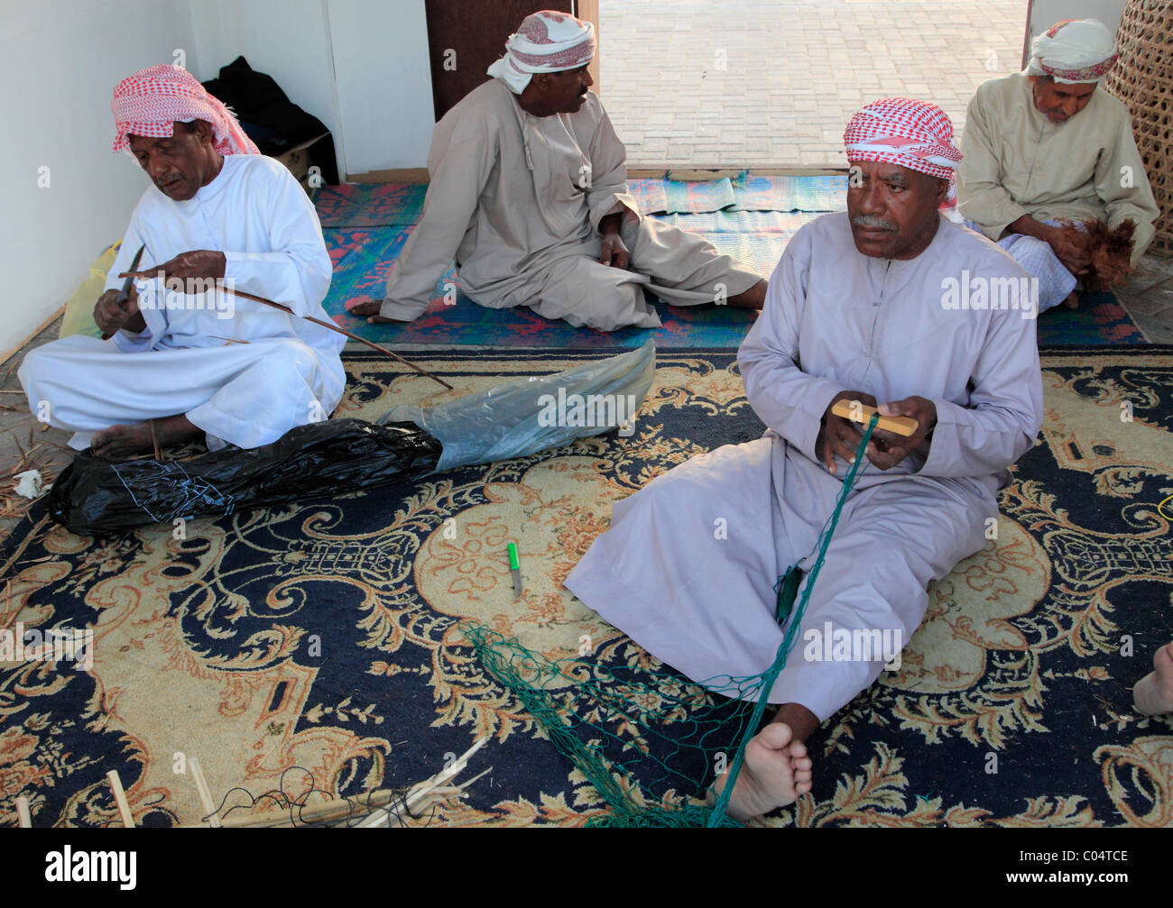 United Arab Emirates, Dubai, old men mending fishing nets, Stock Photo