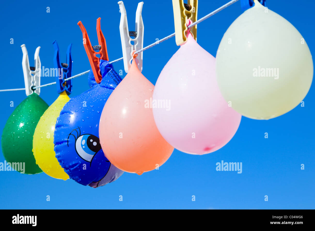Toy fish hidden between balloons hanging from a clothesline Stock Photo