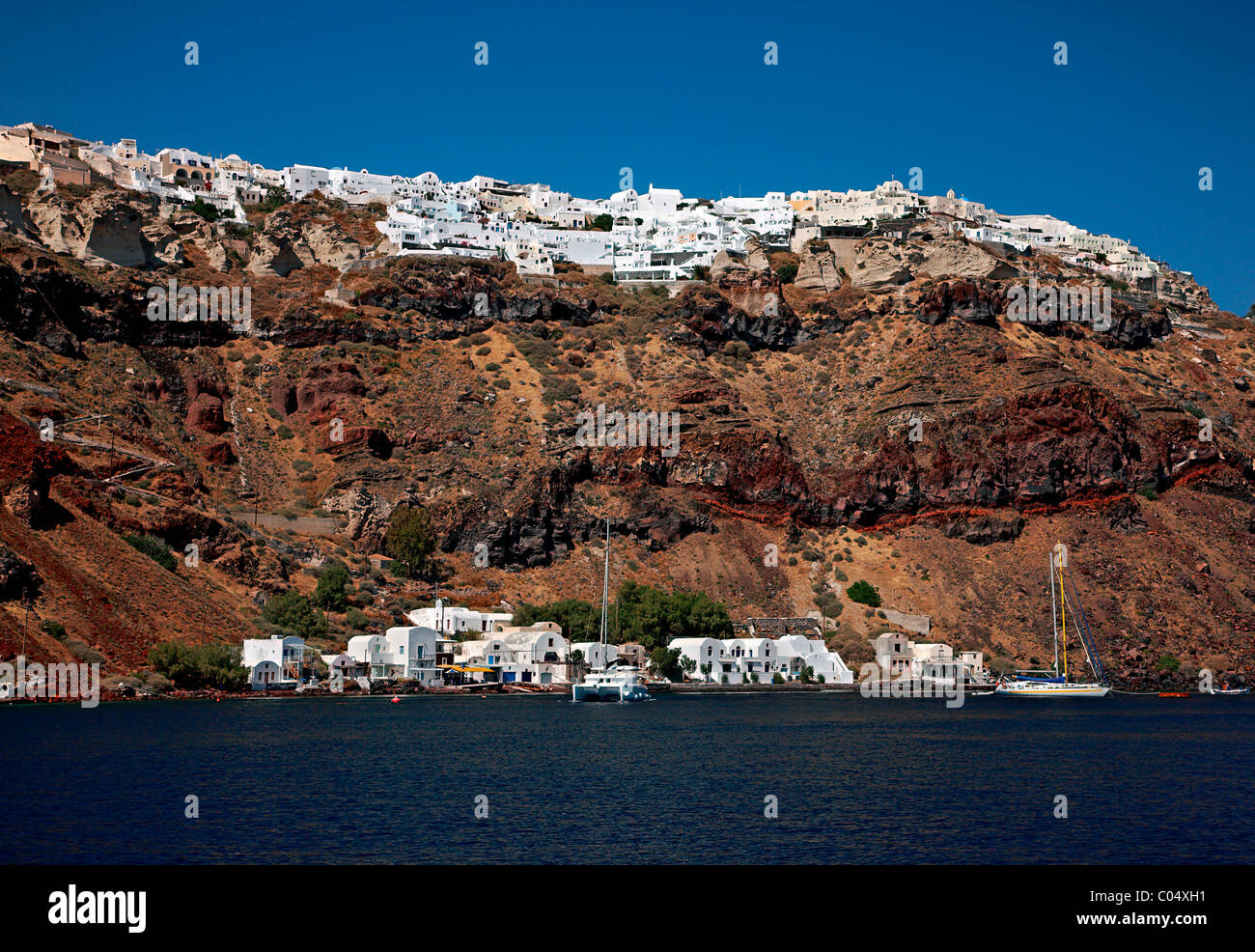 View of Armenis, one of the 2 small harbors of Oia, and Oia itself on the upper part of the photo. Santorini, Greece Stock Photo