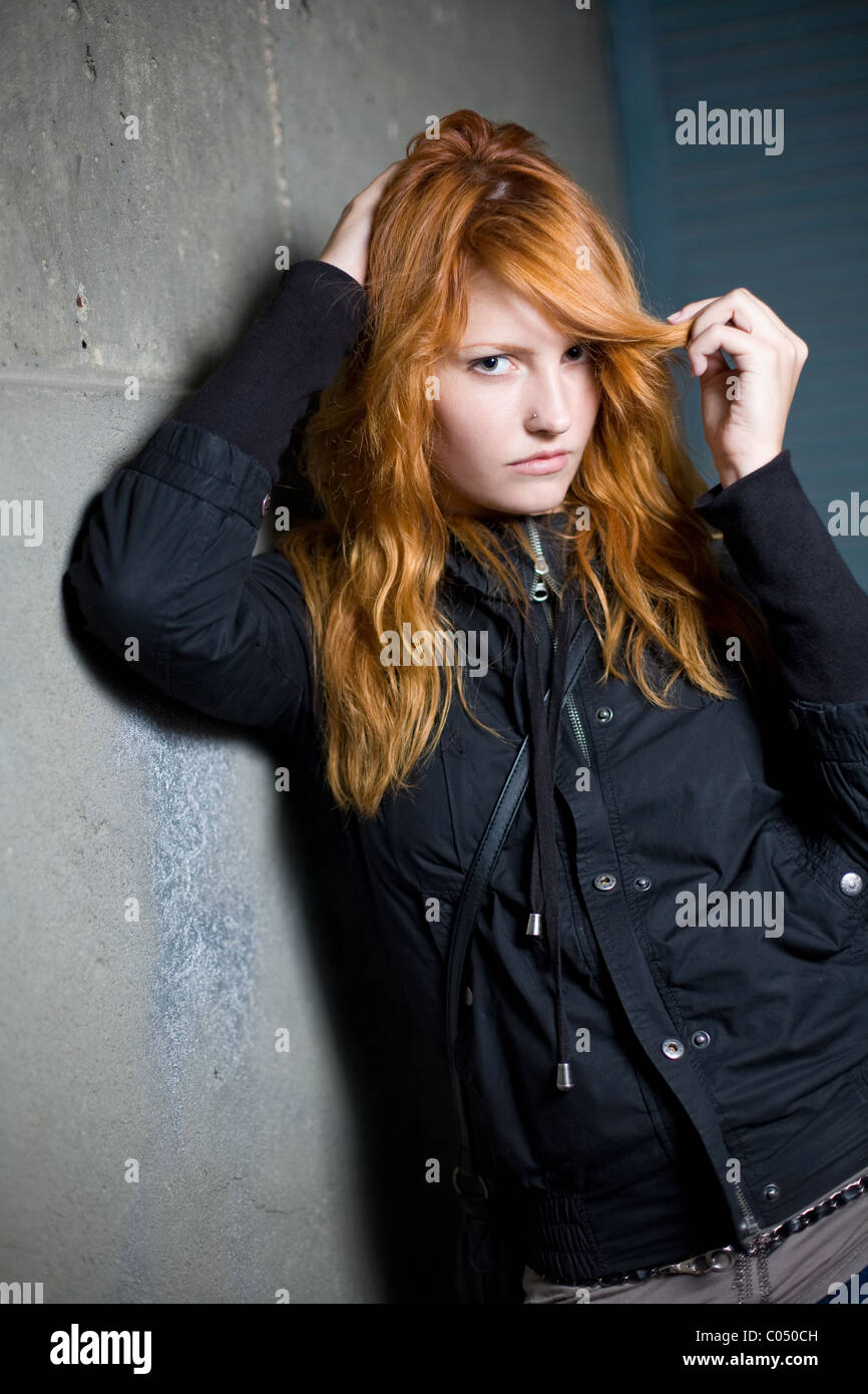 Sad and lonely, moody portrait of a beautiful fashoinable young redhead girl. Stock Photo