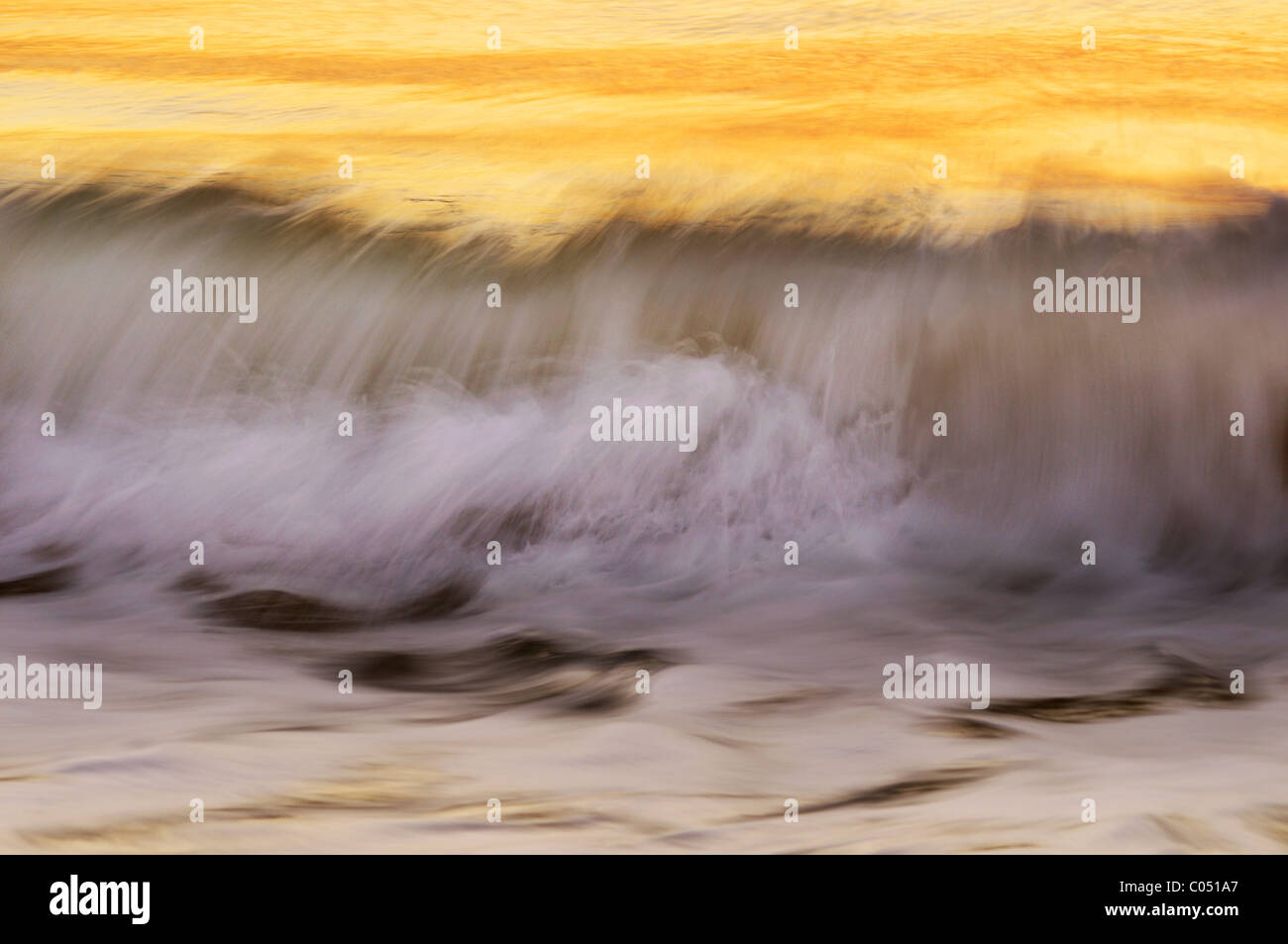 Waves breaking in the early morning light Stock Photo