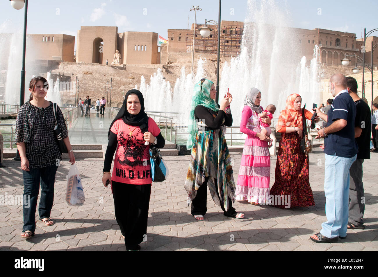 A group of Kurdish people socializing in the main public square, below the old city walls and citadel, in the city of Erbil, Kurdistan, northern Iraq. Stock Photo