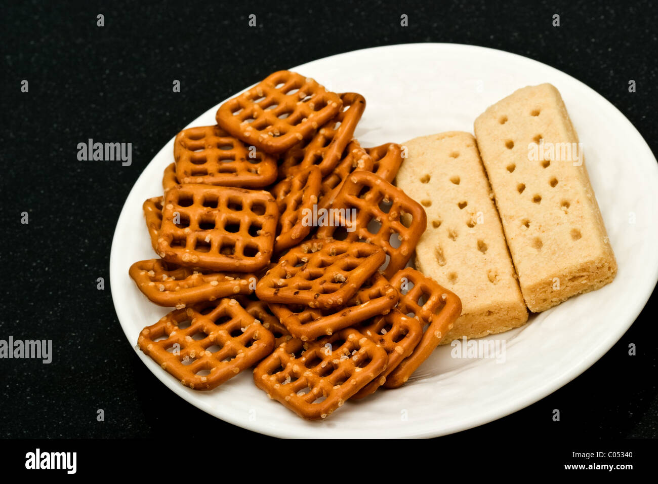 Two shortbread cookie fingers with snack food on a white plate Stock Photo