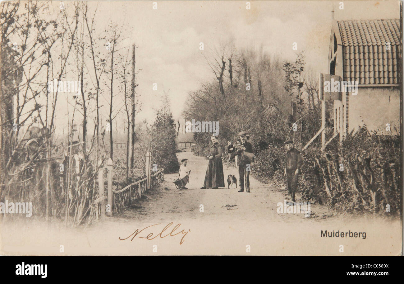 Mailman and family on sandy road in Muiderberg in the Netherlands on old postcard Stock Photo