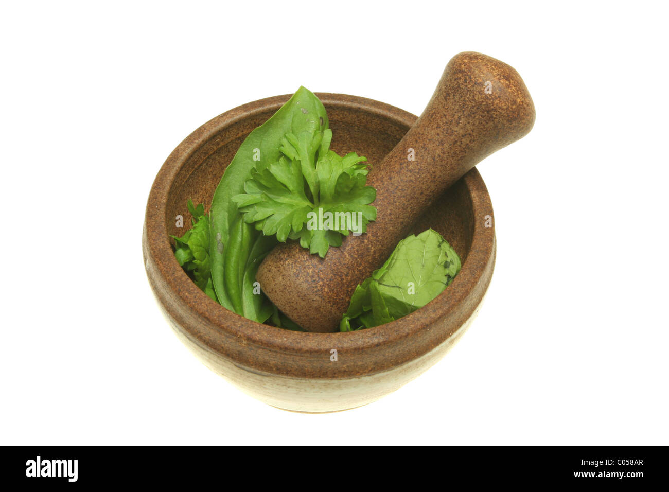 Fresh herbs in a pestle and mortar isolated on white Stock Photo