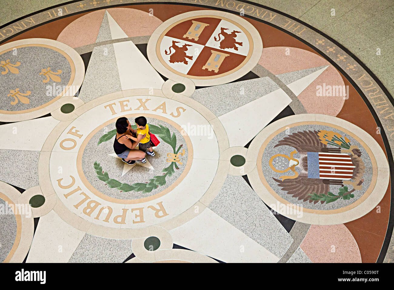 Woman and child standing on center star on floor of the Texas State Capitol Building Austin Texas USA Stock Photo