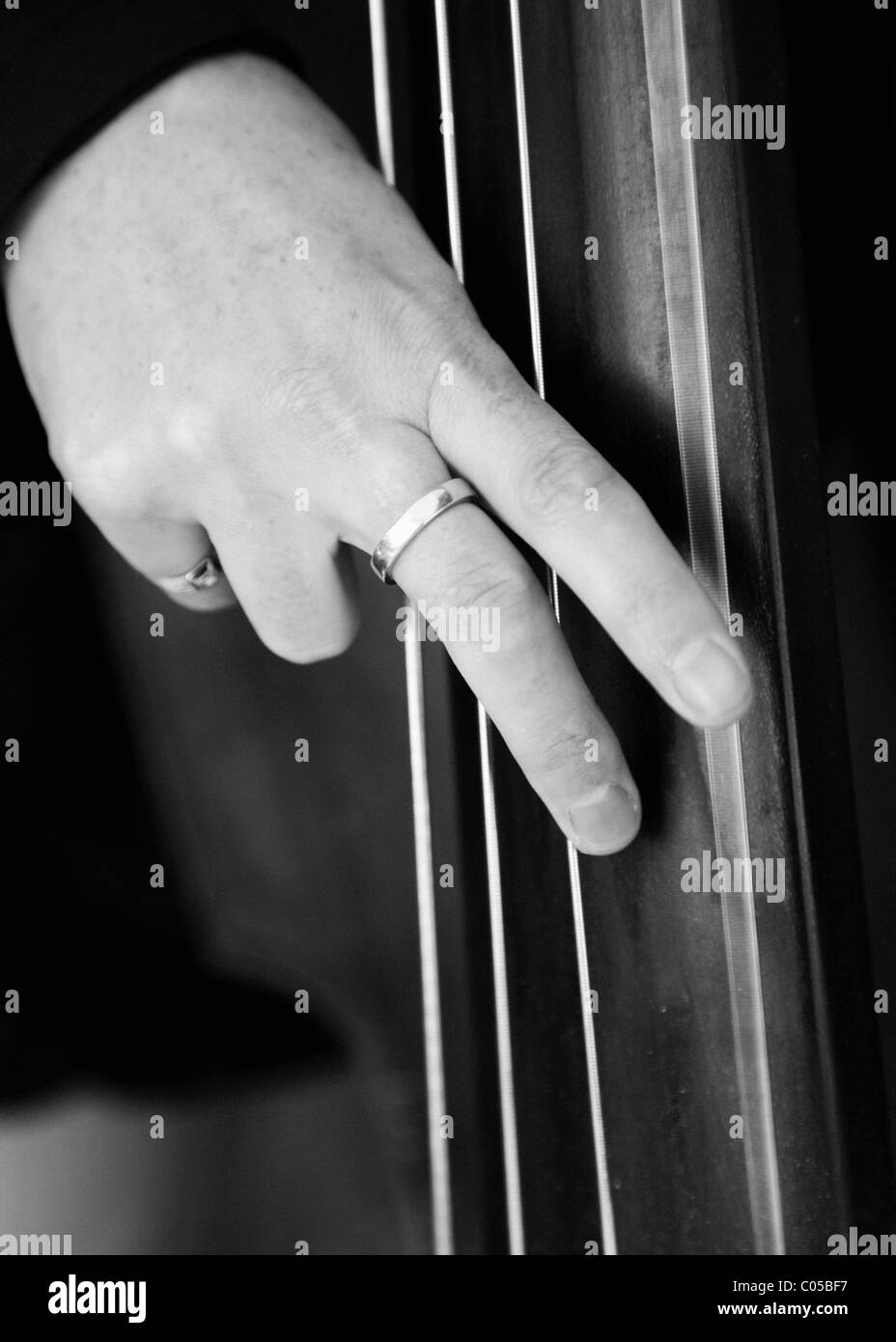 Black and white image of  a lady playing a double bass Stock Photo