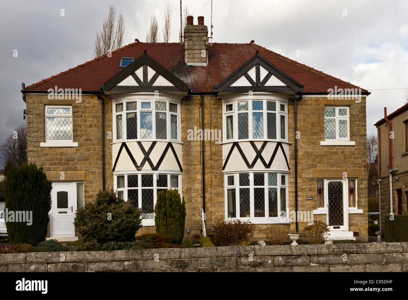 Well-maintained pair of semi-detached houses faced with stone and with tiled roof, circa 1930s, Stock Photo