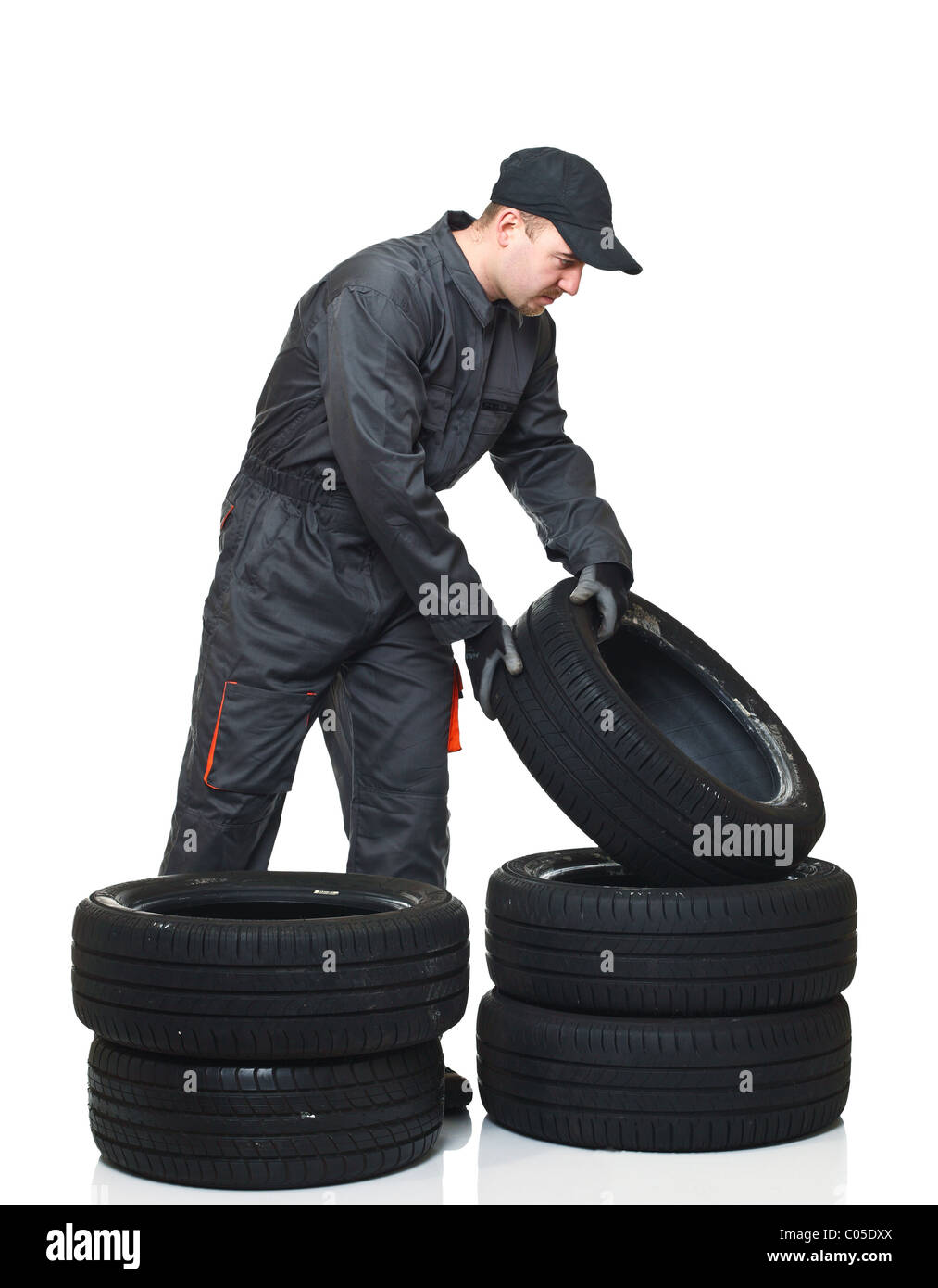 young mechanic move tires isolated on white background Stock Photo