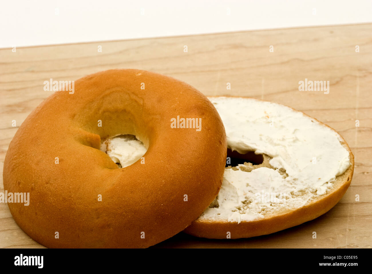 Bagel with cream cheese on a cutting board Stock Photo