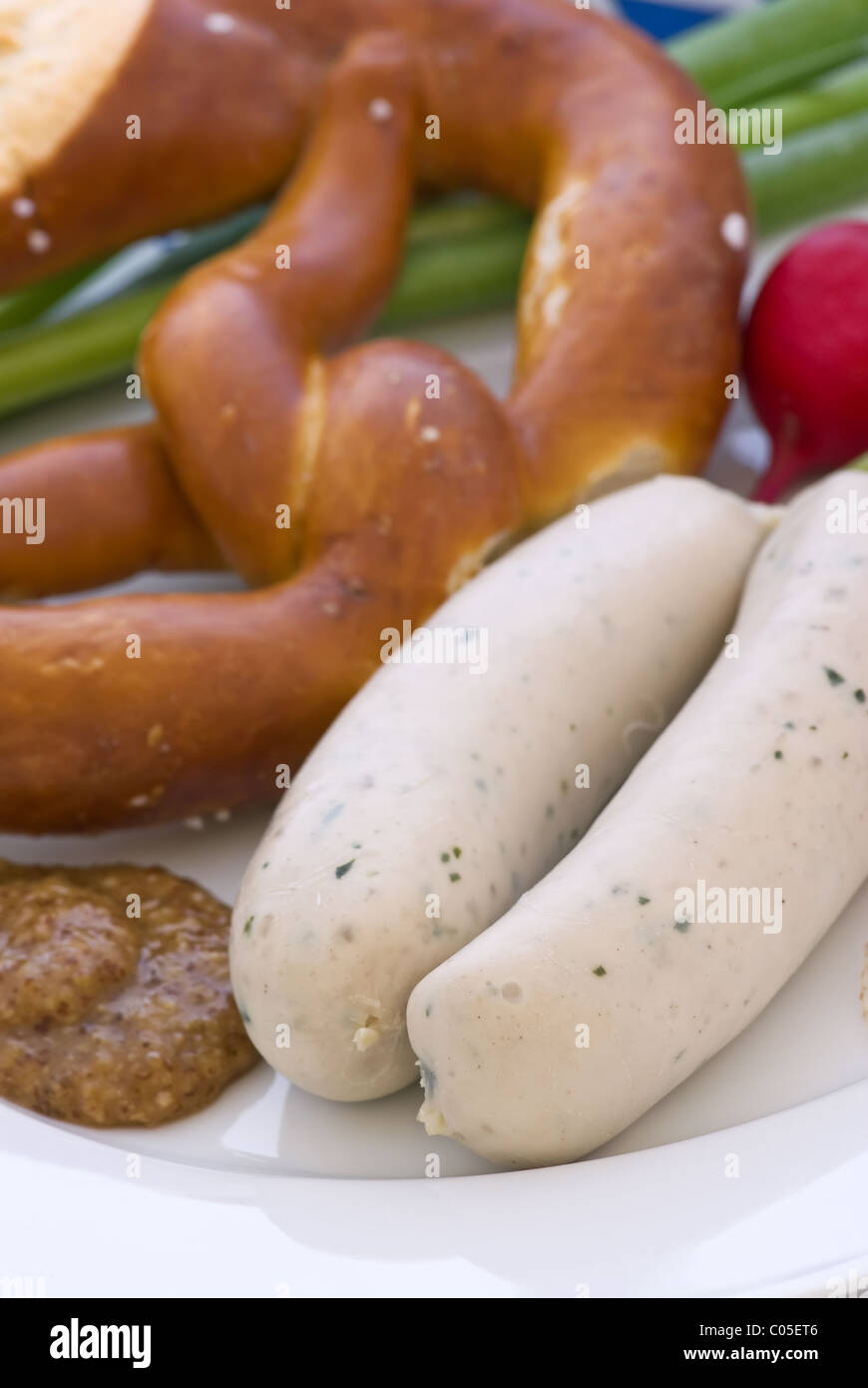 Sausage with Pretzel and sweet mustard  as closeup on a white plate Stock Photo