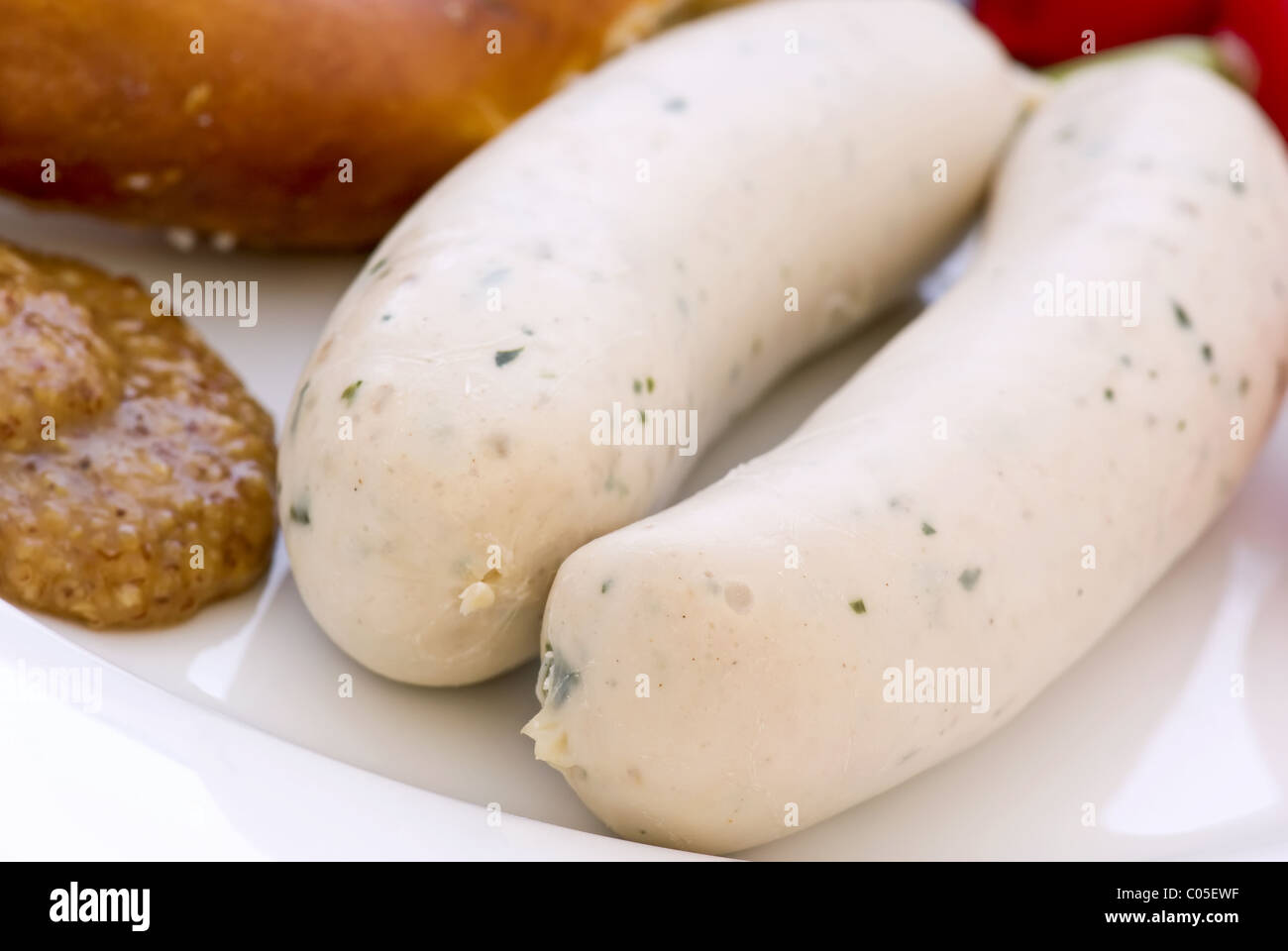 Sausage with Pretzel and sweet mustard  as closeup on a white plate Stock Photo