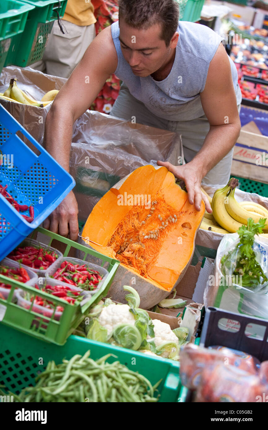 Cutting up fresh portions of melon at greengrocers . Fresh fruit and