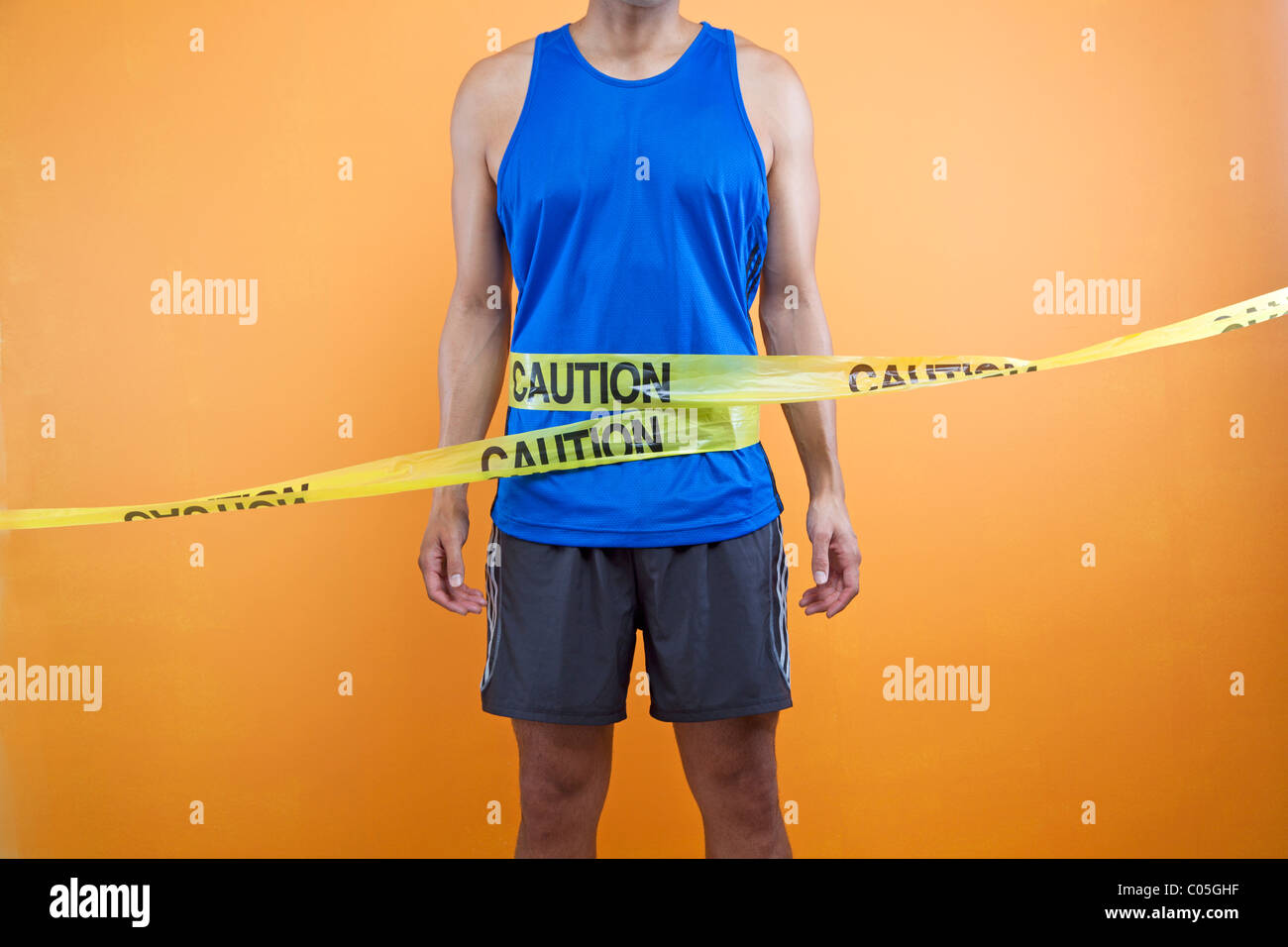 runner with caution tape wrapped around waist Stock Photo