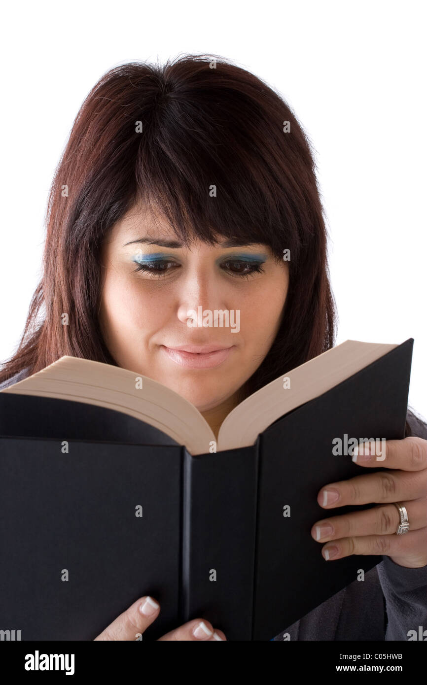A young woman reading a book with a concerned expression on her face