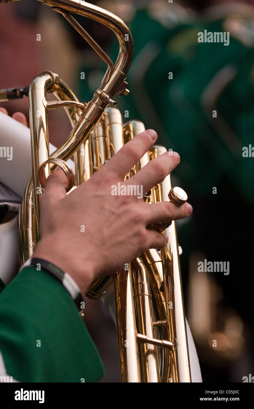 Close up of a male hand playing the tuba in a marching band. Shallow depth of field. Stock Photo