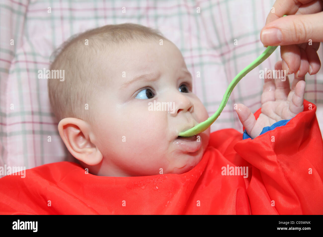 First time with a spoon. Baby eating porridge Stock Photo Alamy