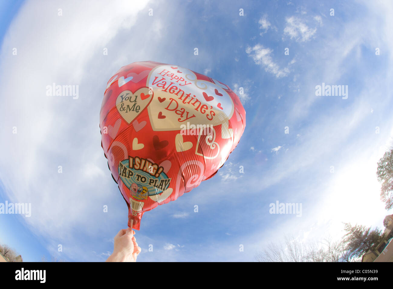 Happy Valentines Day helium balloon with blue sky, heart shapes 'singing balloon' -sings a song when you touch balloon. Stock Photo
