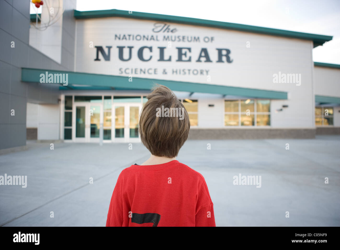 Young boy standing in front of The National Museum of Nuclear Science and History, Albuquerque, New Mexico. Stock Photo