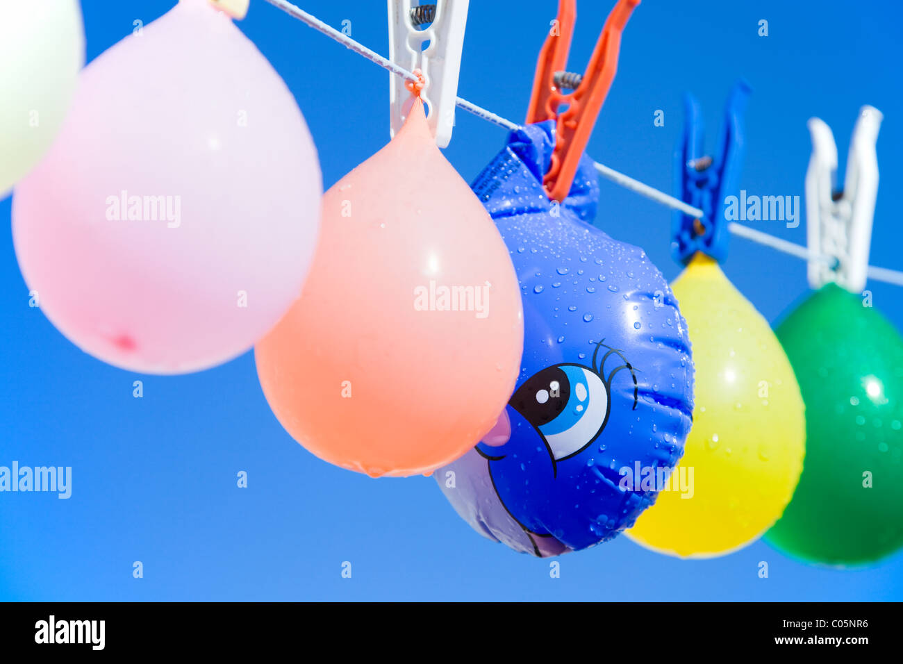 Toy fish hidden between balloons hanging from a clothesline Stock Photo