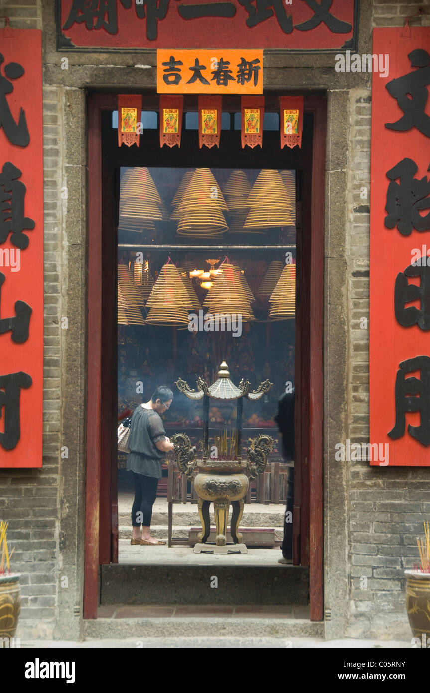 China, Hong Kong, New Territories, Tai Po area. Entry to famous Man Mo Temple, burning incense as offering. Stock Photo