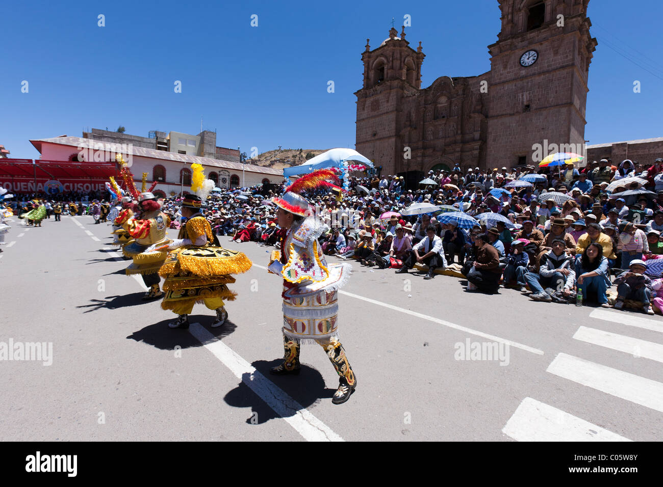 Rows of school children in costume dance before the stand during Puno Week celebrations Stock Photo
